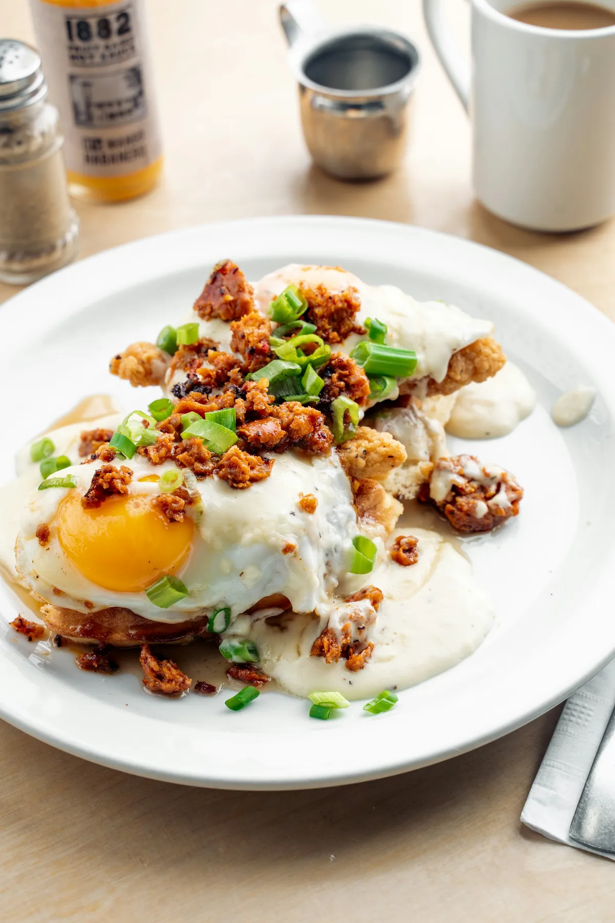 Biscuits and gravy topped with a fried egg and green onion